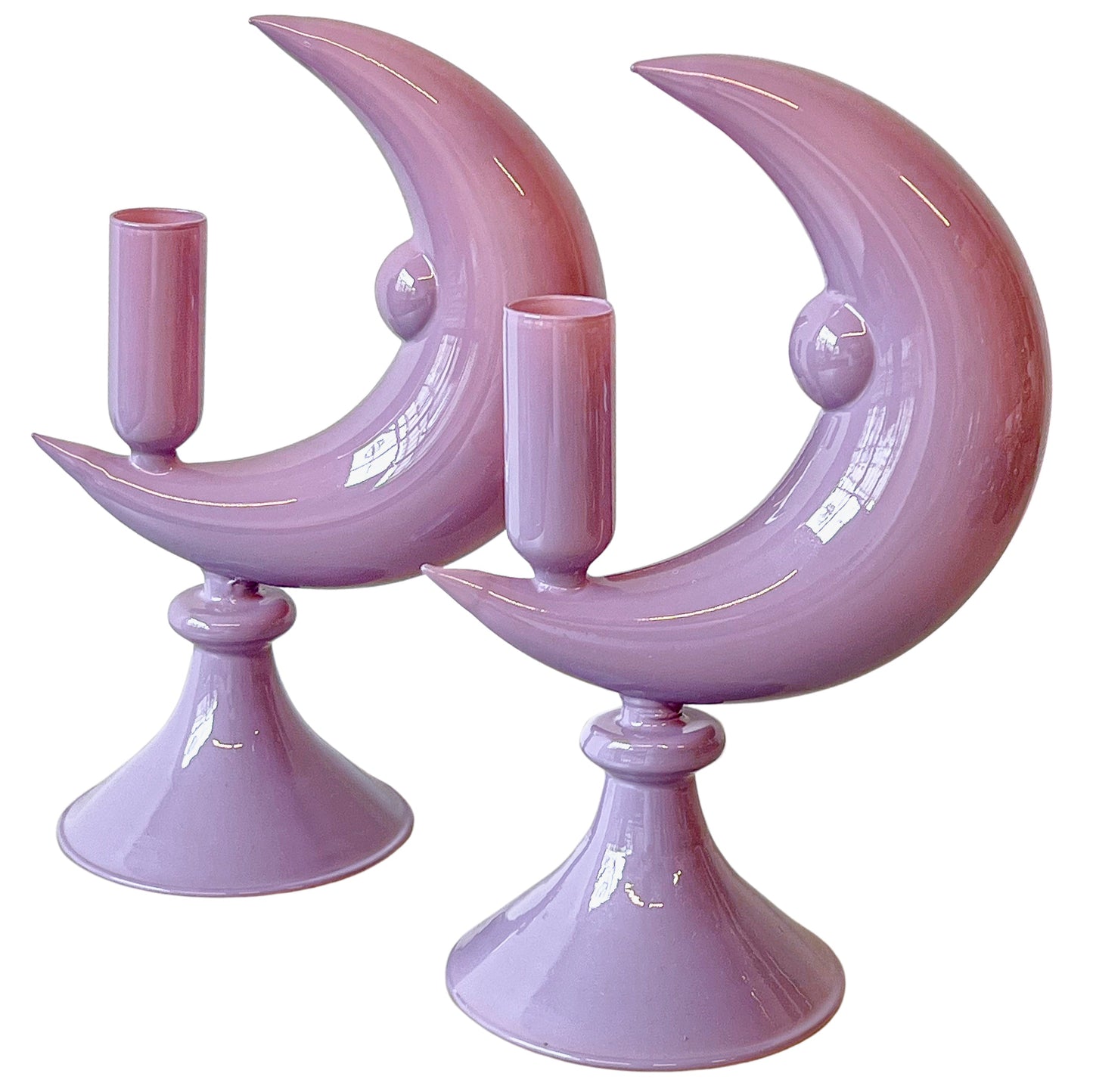 Two purple moon-shaped candle holders on a white background