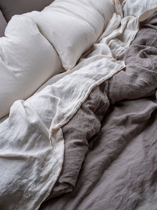 Close-up of soft, textured bedding with a pillow and blanket.